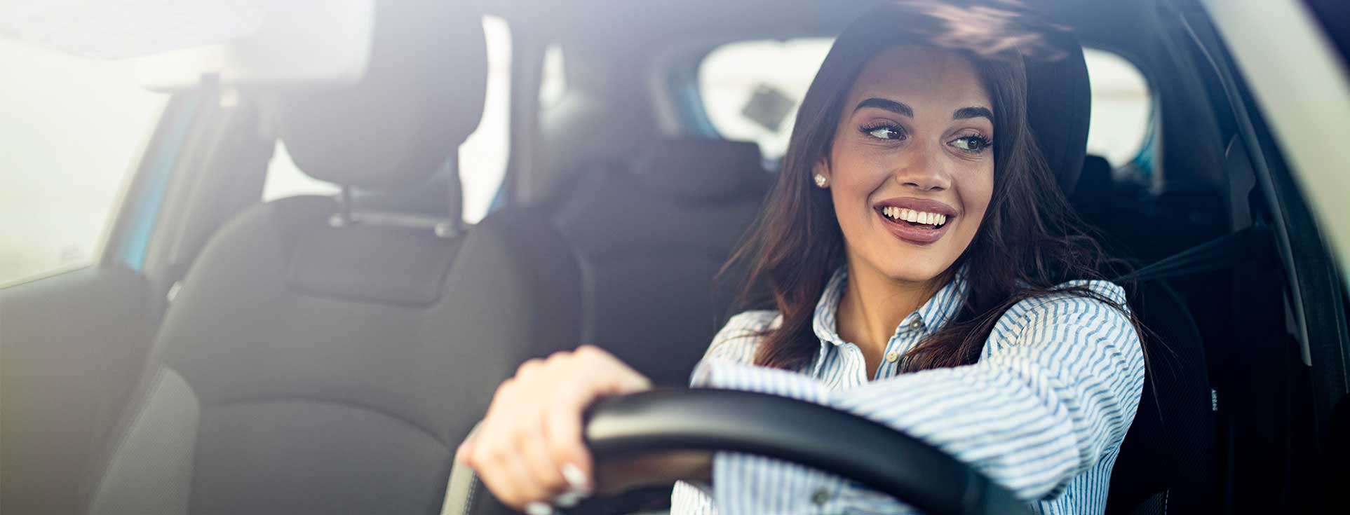 Woman smiling while driving vehicle